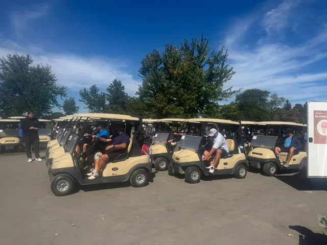 Golfers seated in rows of golf carts on the cart path, preparing to head out during the Rose City Kids Golf Tournament.