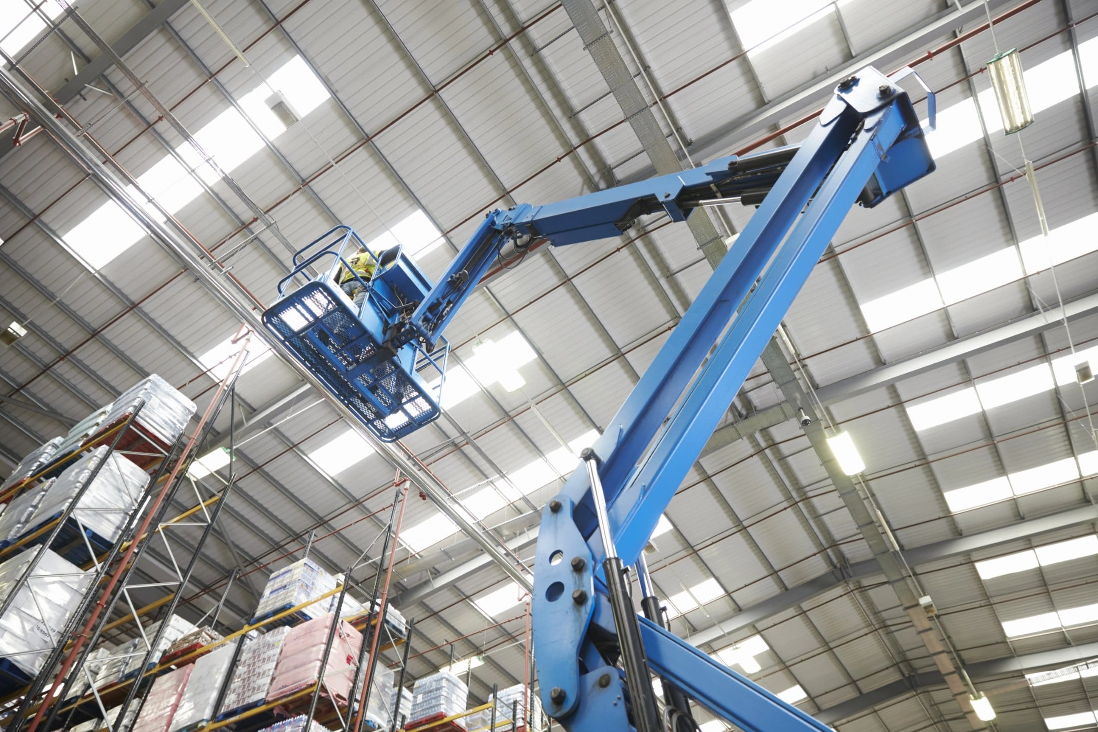 Crew installing high-bay LED fixtures from a boom lift in a warehouse